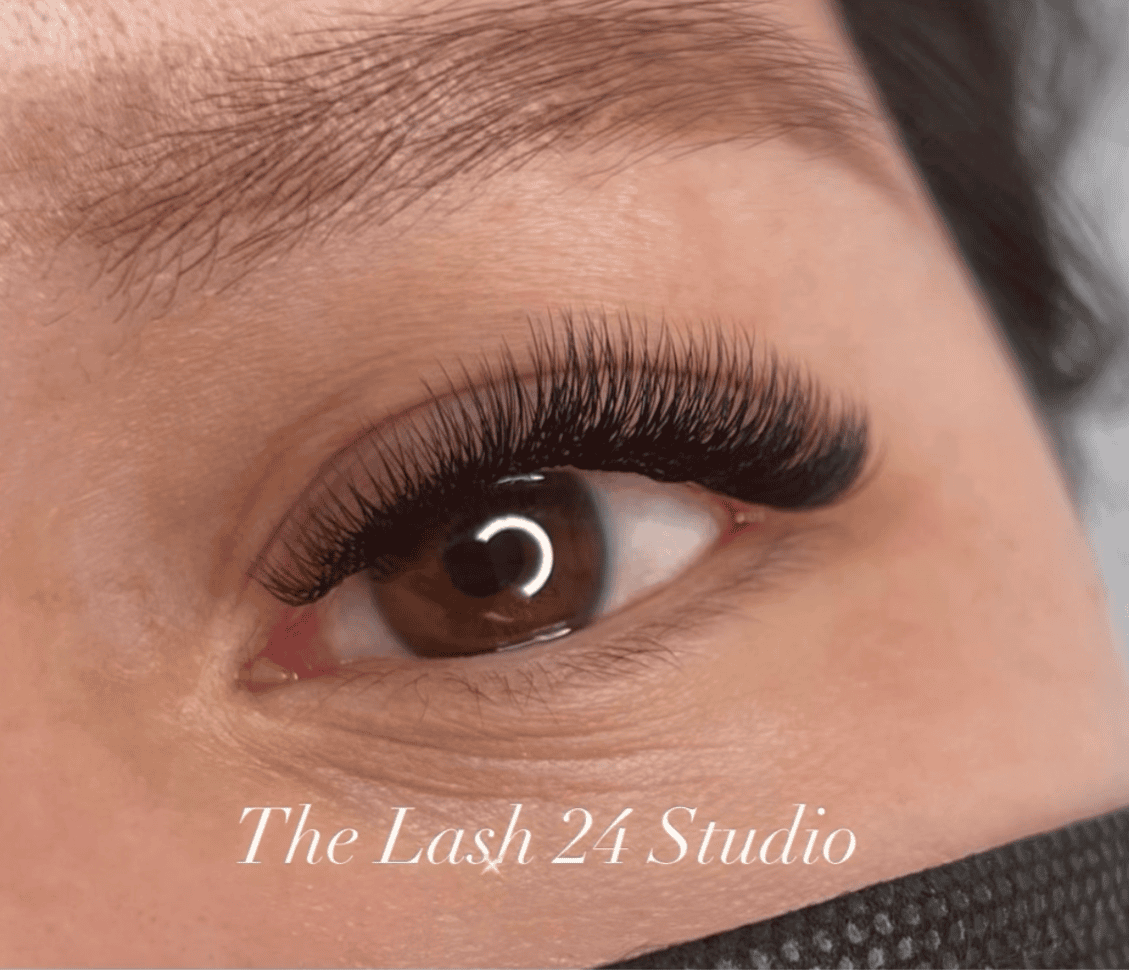 Close-up of a client showing a dense, full Elegant Volume lash extension set by The Lash 24 Studio.